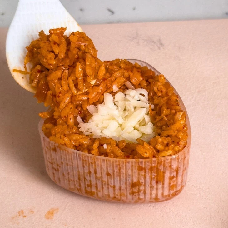 Filling an onigiri mold with a cheese stuff kimchi rice ball.