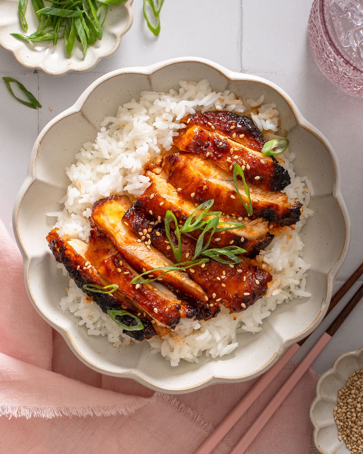 A top down view of a bowl of rice topped with gochujang chicken.