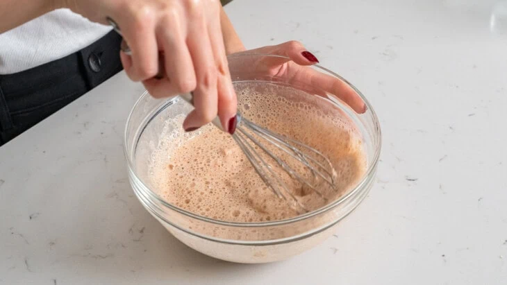 Mixing together a batter for frying with a whisk.