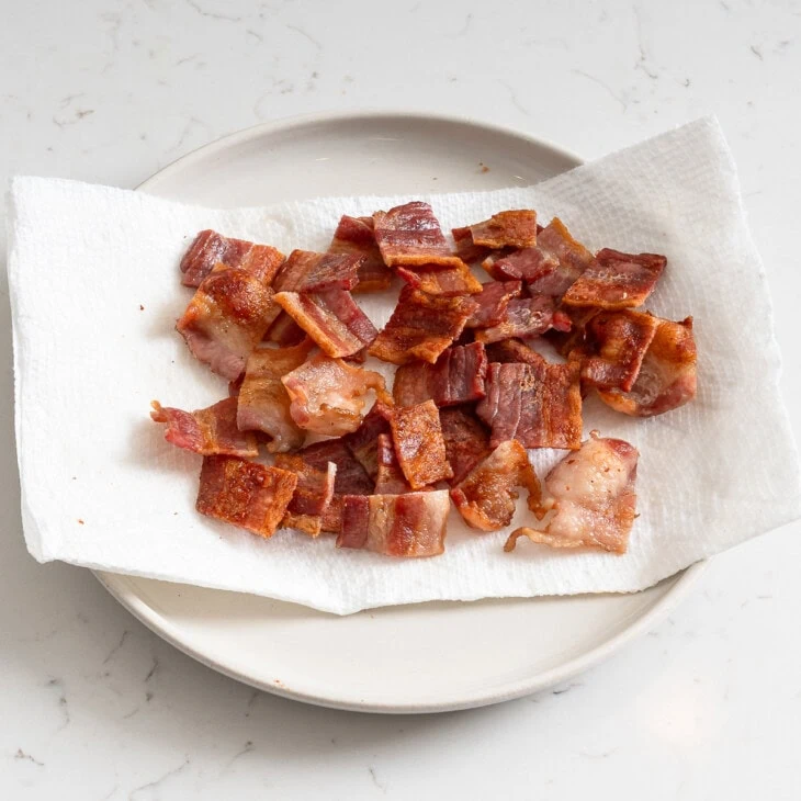 Cooked bacon chopped up on plate.