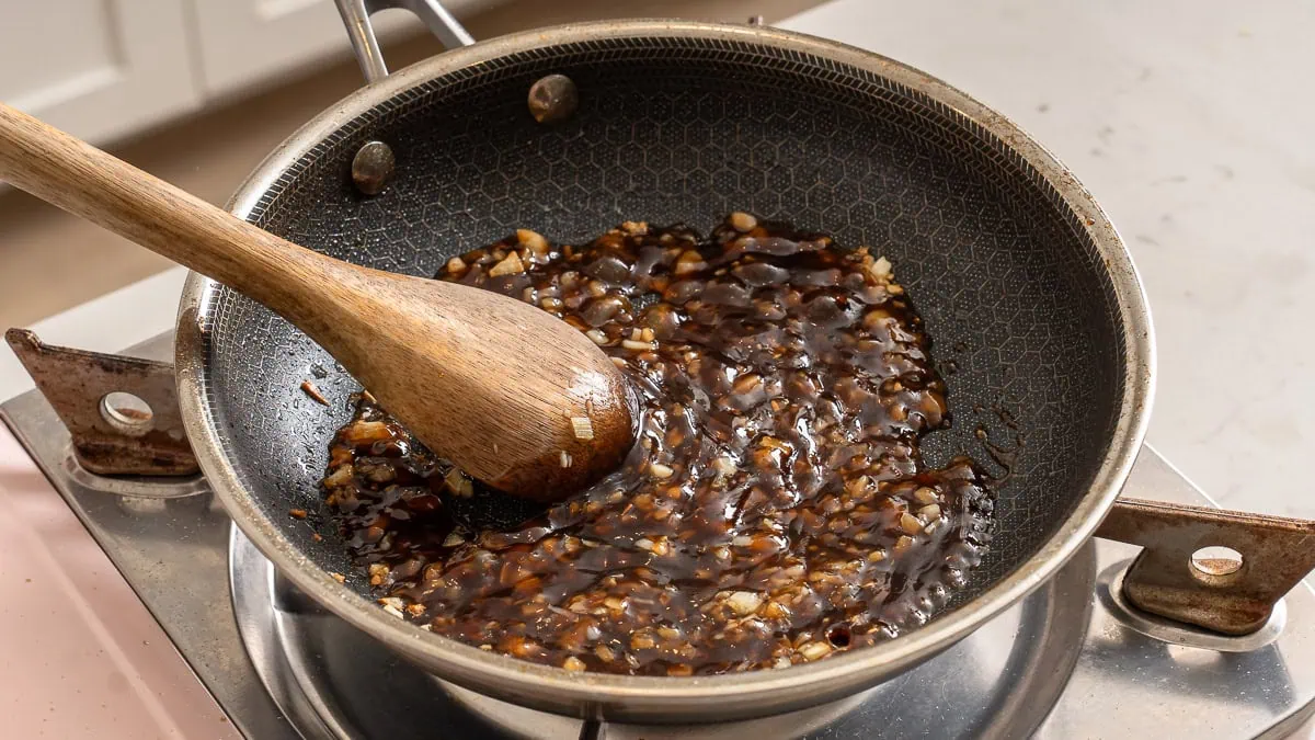 Cooking oyster sauce with minced aromatics.