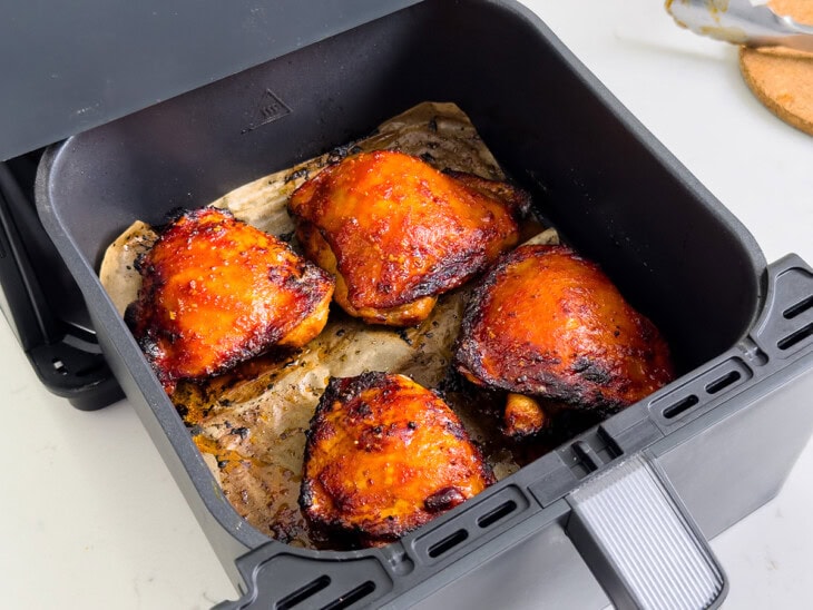 Chicken thighs after being flipped in an air fryer.