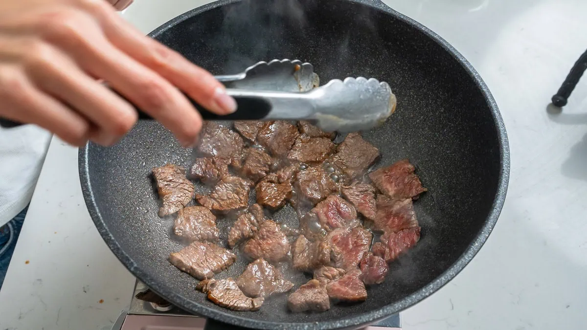 Cooking beef inside a wok.