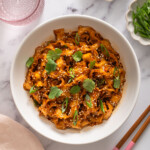 A top down view of a bowl of noodles in a garlic chili oil sauce.
