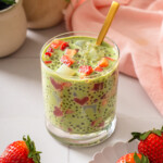 A cup full of strawberry matcha sago with a spoon in it.