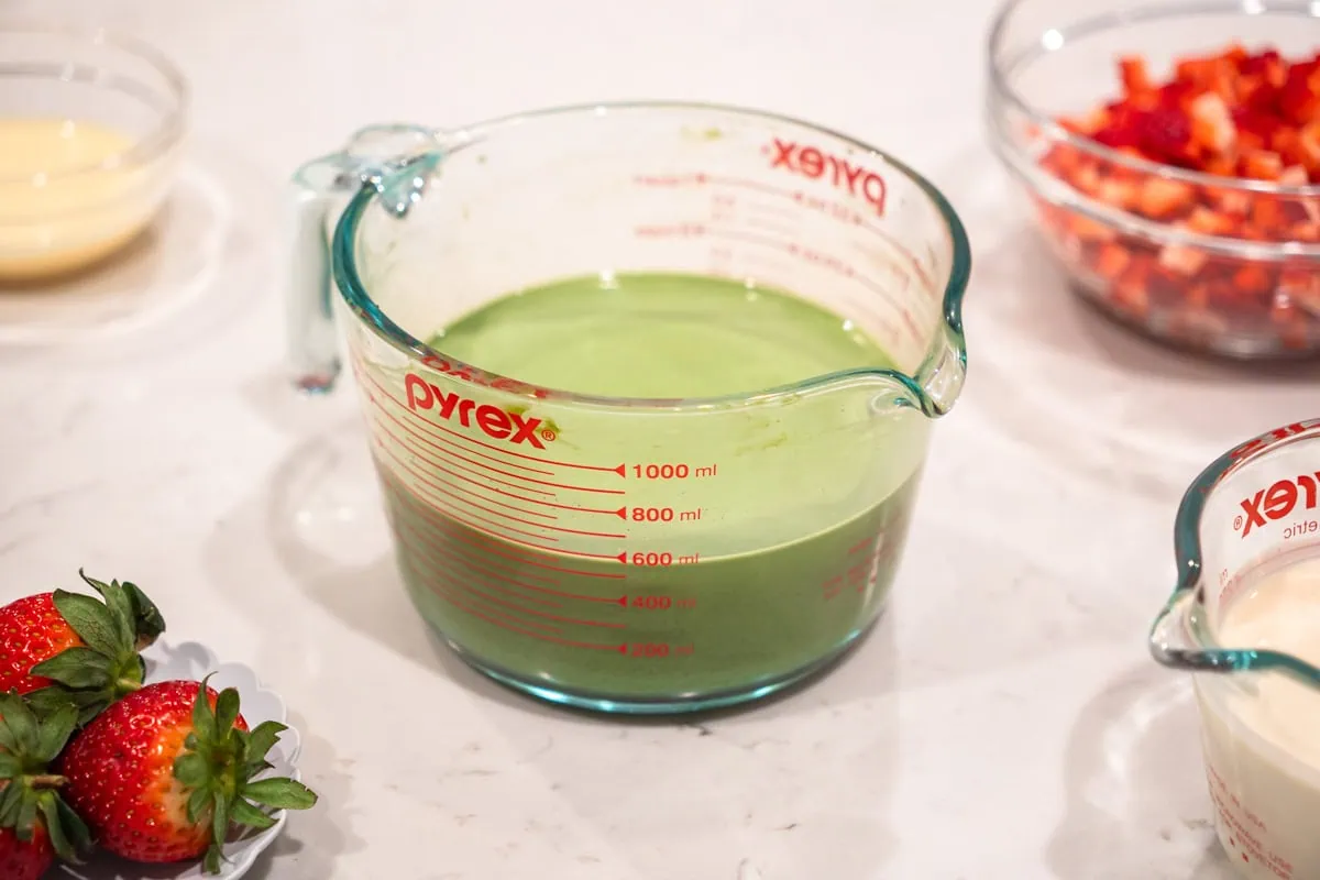 A measuring cup full of matcha milk.