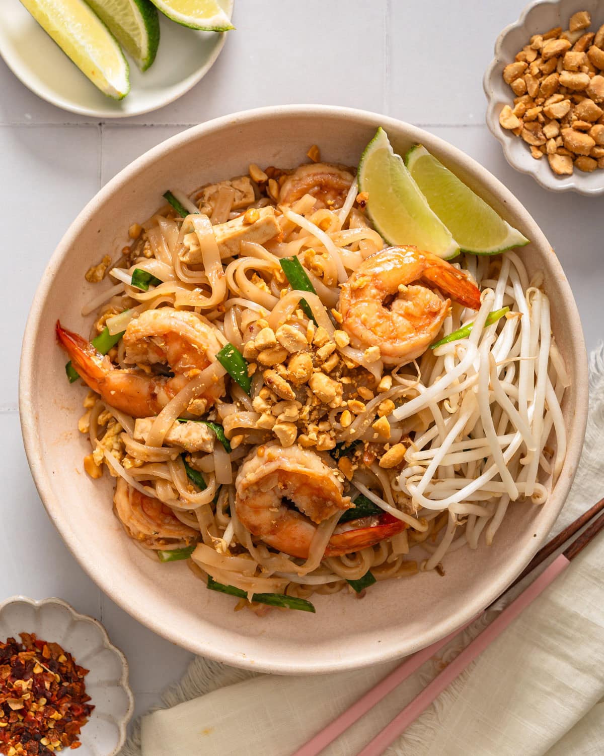 A plate of shrimp pad thai viewed from overhead.