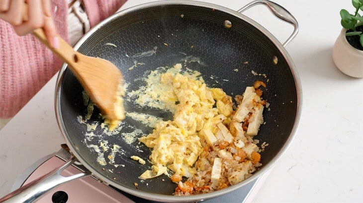 Scrambling eggs inside a wok.