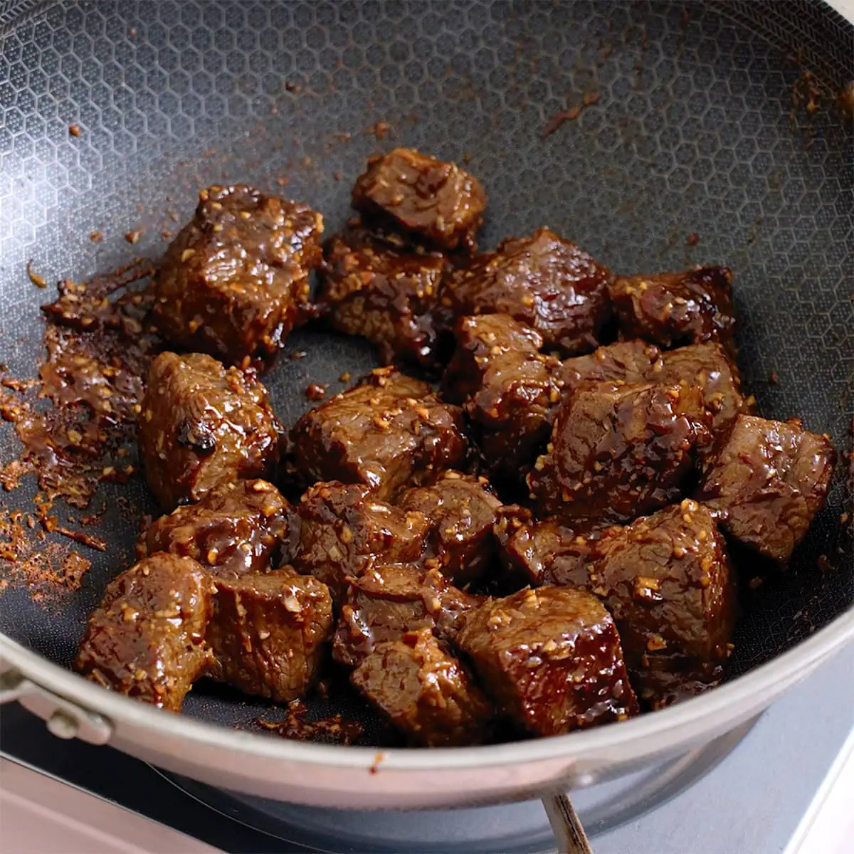 Cubes of beef browned in a wok.