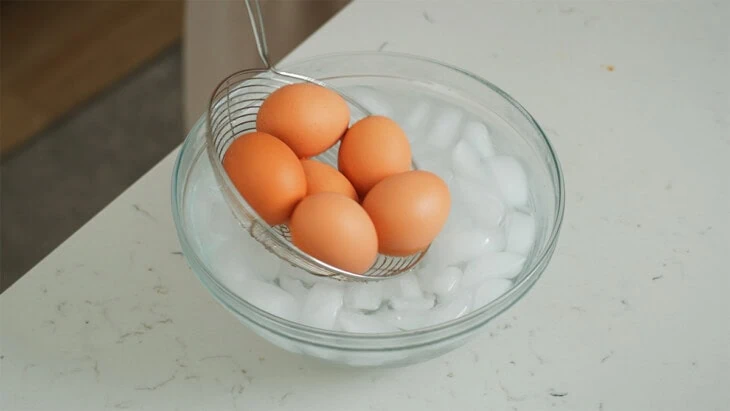 Placing eggs in an ice bath.