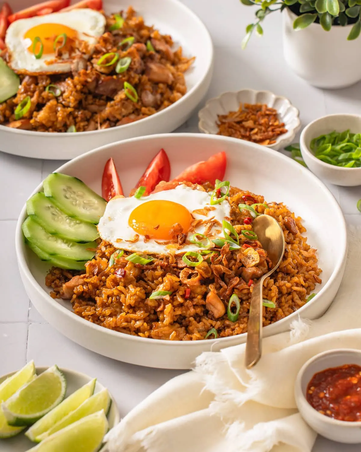 Two plates of nasi goreng in a table spread.