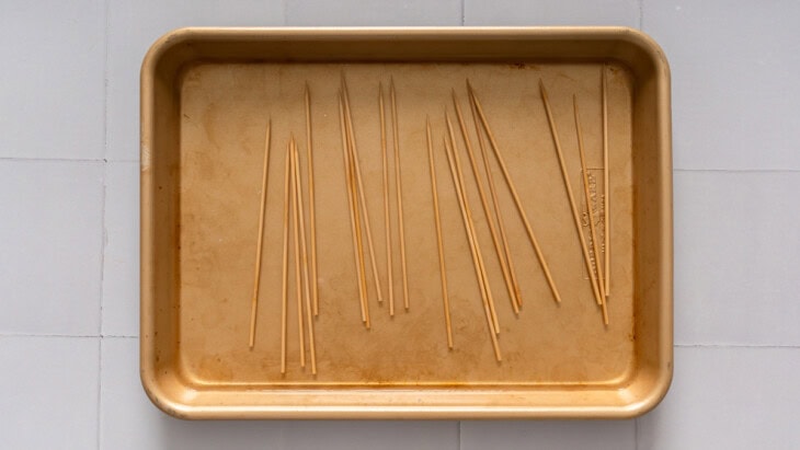 Small wooden skewers being soaked in water.
