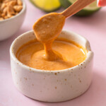 A small spoon lifting up Thai peanut sauce.