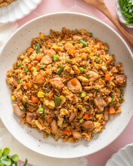 A top down view of platter of Chinese chicken fried rice on a table.