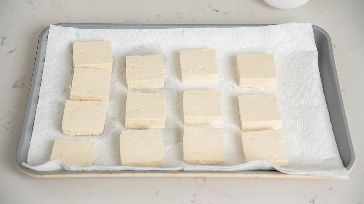 A tray of sliced firm tofu draining.