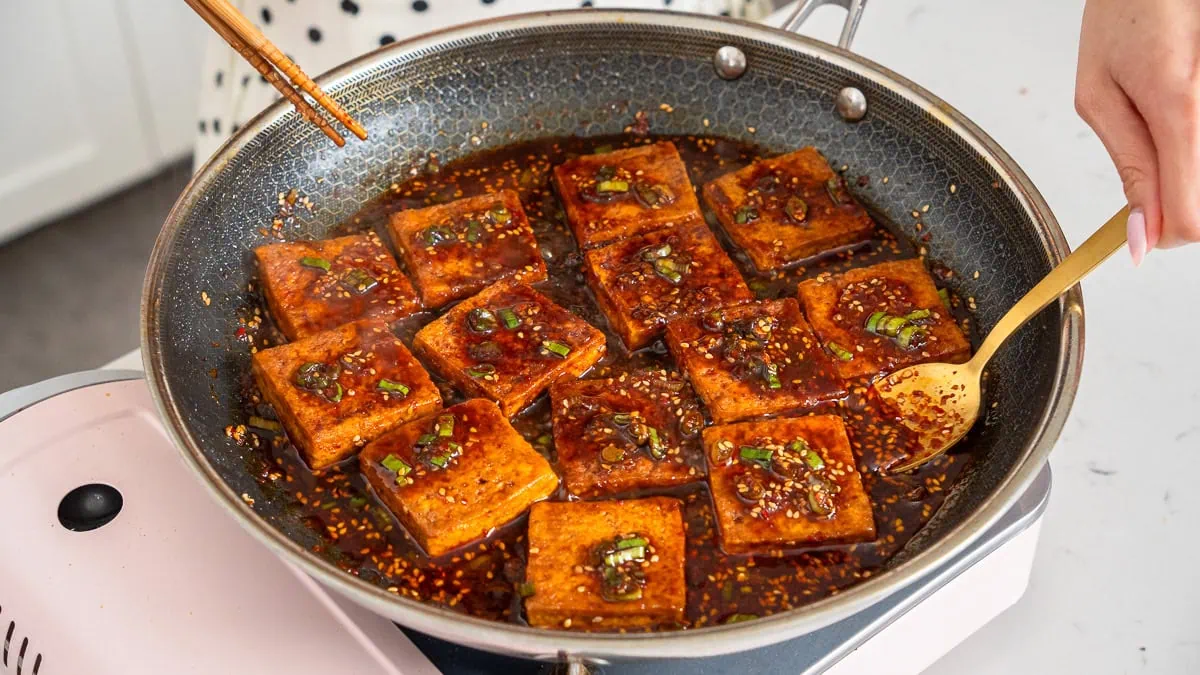Cooking Korean braised tofu in a deep skillet.