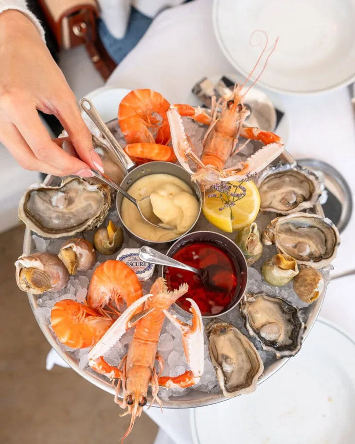 A large cold seafood platter with dipping sauces,