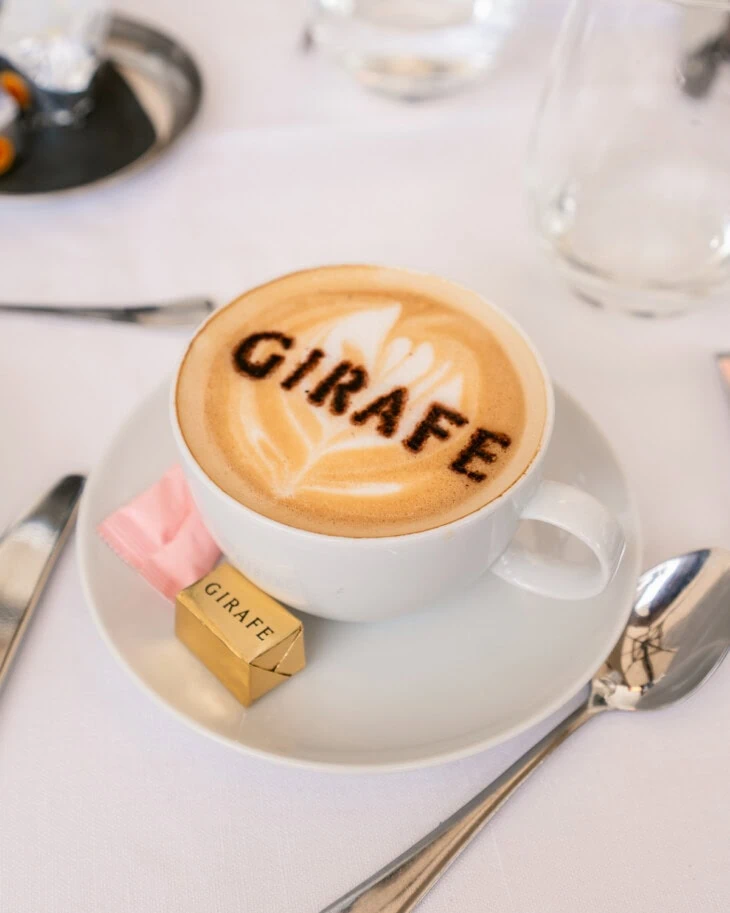 A branded cappuchino with the restaurants name on it.